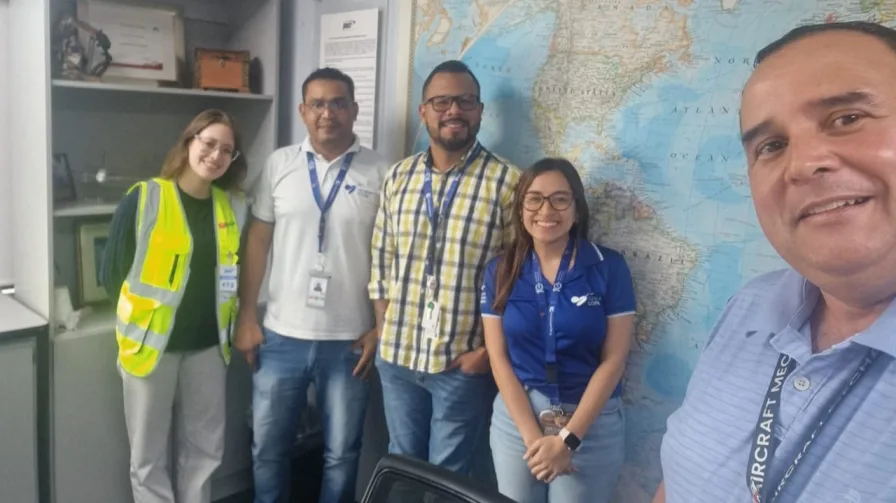 A Belli implementation lead with an airline's cargo operations team in front of a world map.
