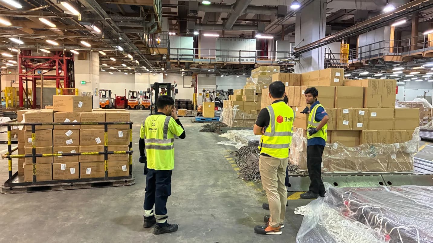 A Belli implementation lead reviewing pallets with warehouse staff on a cargo acceptance floor.