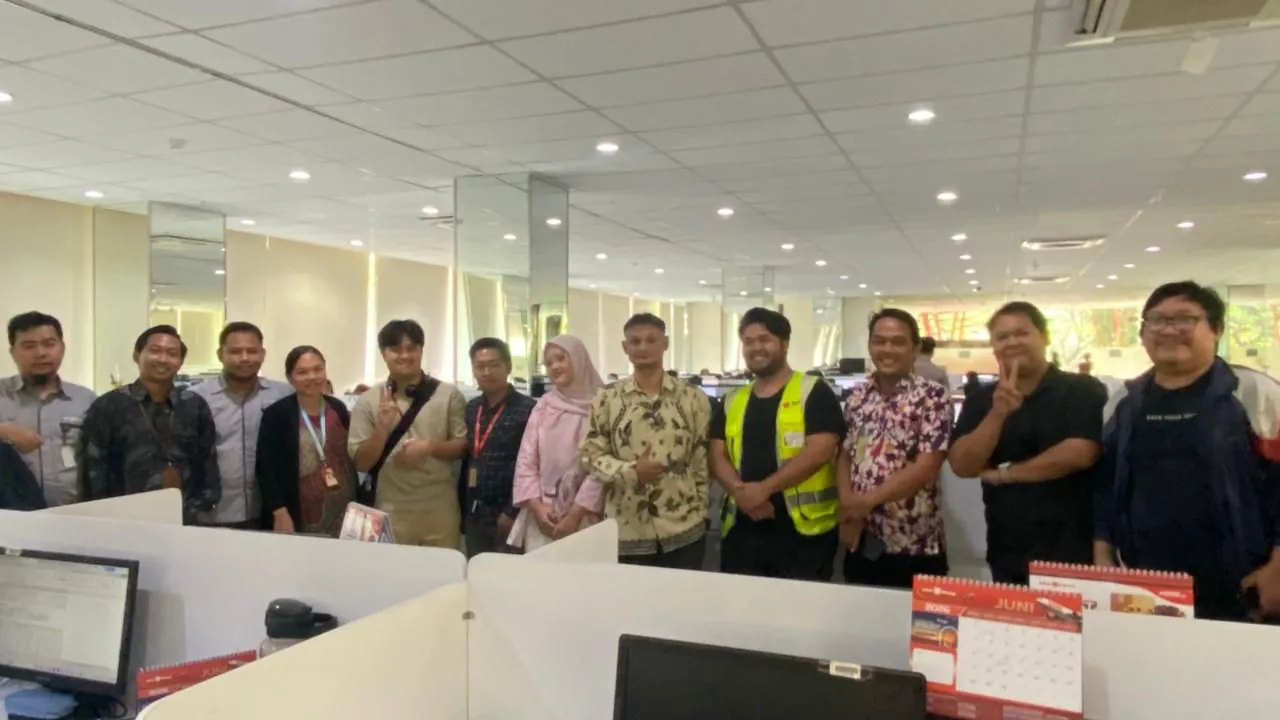 The team standing with airline staff in an open-plan cargo office