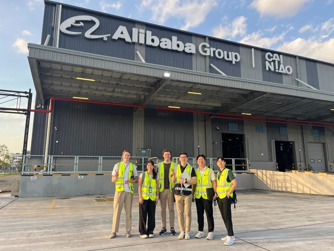 Six associates in Belli hi-vis outside an Alibaba Group Cainiao cargo facility