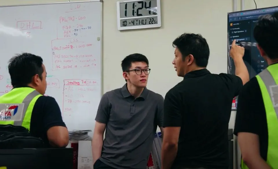 Engineers working through a problem at a whiteboard with airline ground staff