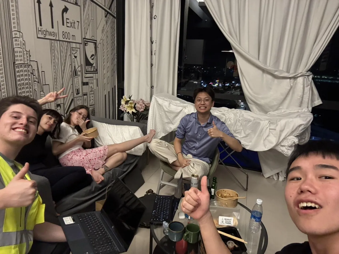 The team together at a rented flat, laptops out, after a day on site